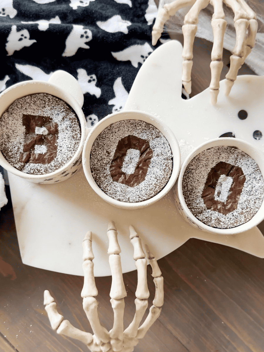 Easy halloween brownies with BOO design on ghost tray. Skeleton hands with ghost towel for added decor.