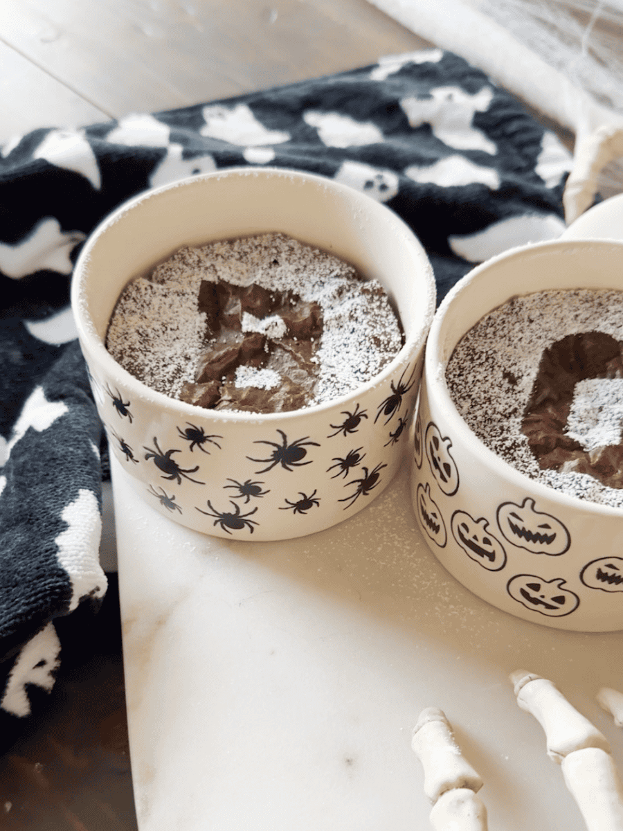 Close up shot of Easy halloween brownies with BOO design on ghost tray. Skeleton hands with ghost towel for added decor.
