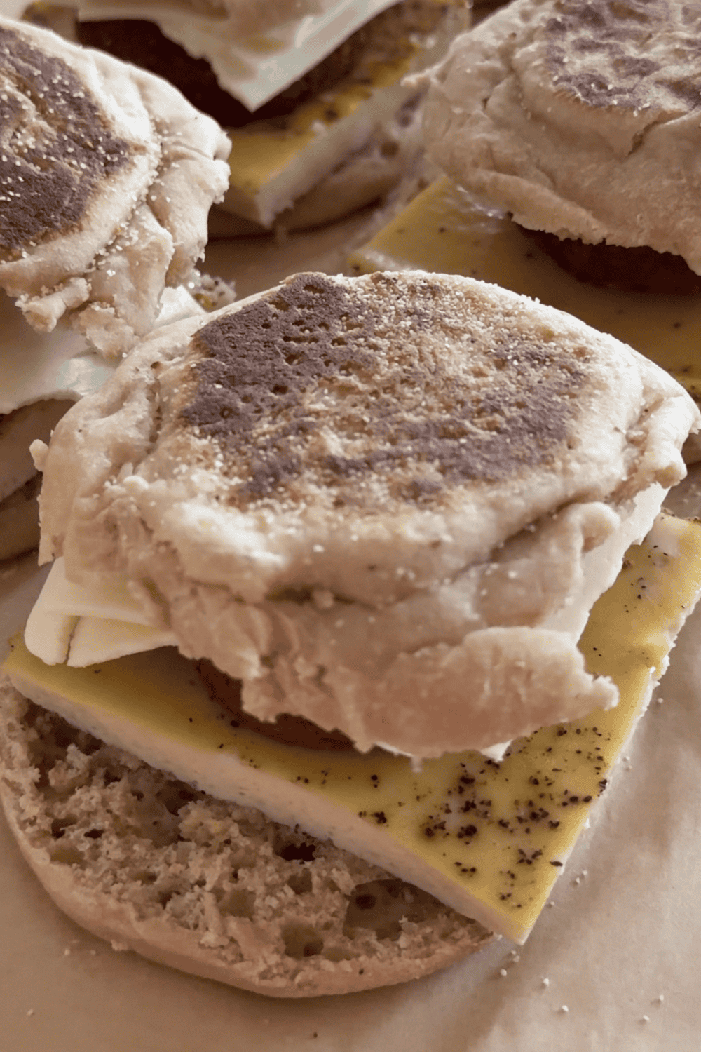 Easy high-protein breakfast sandwich meal prep with sheet pan egg, sausage, and cheese on an English muffin