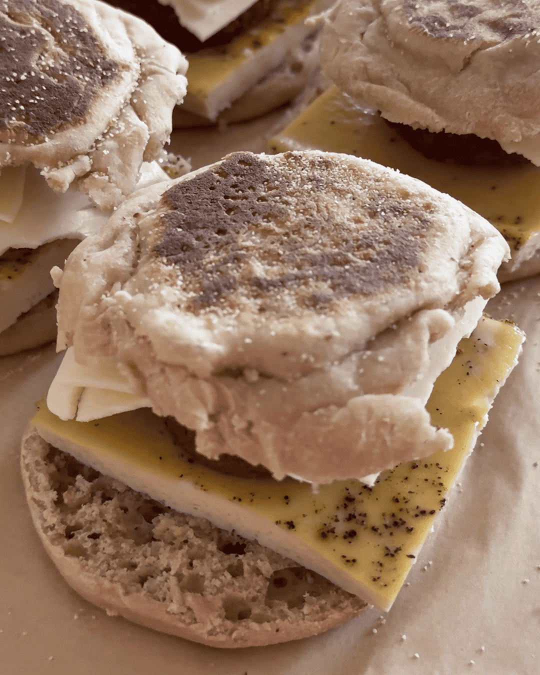High-protein breakfast sandwich with sheet pan egg, sausage, and cheese on an English muffin